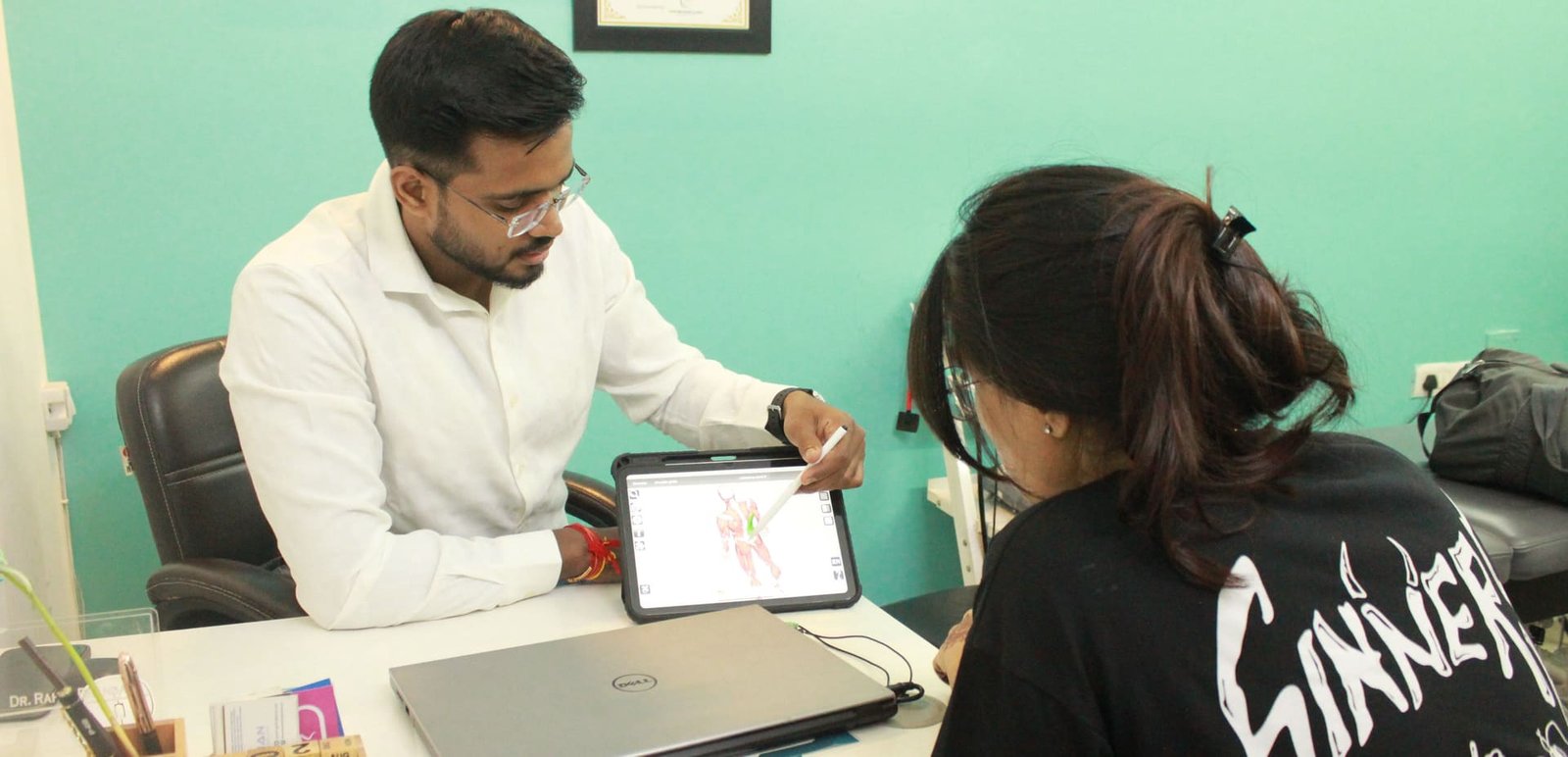 Physiotherapist explaining a treatment plan using 3D anatomy visualization at Symphysio, Sarita Vihar